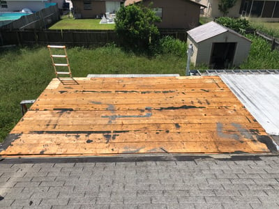 roof tear-off showing wood decking on a low slope roof