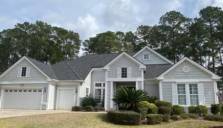 Upgraded black architectural shingles on a large light gray home