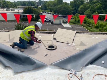 roofer installing a roof drain on a flat roof-1