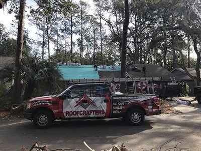 RoofCrafters truck in front of a home being repaired from storm damage