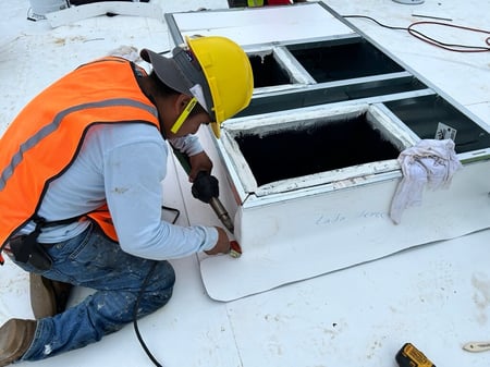 roofer welding a single-ply roof on a HVAC curb