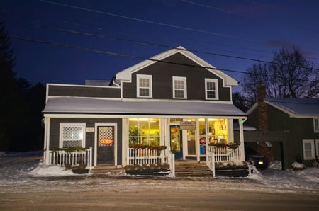 grey house with white trim in snow